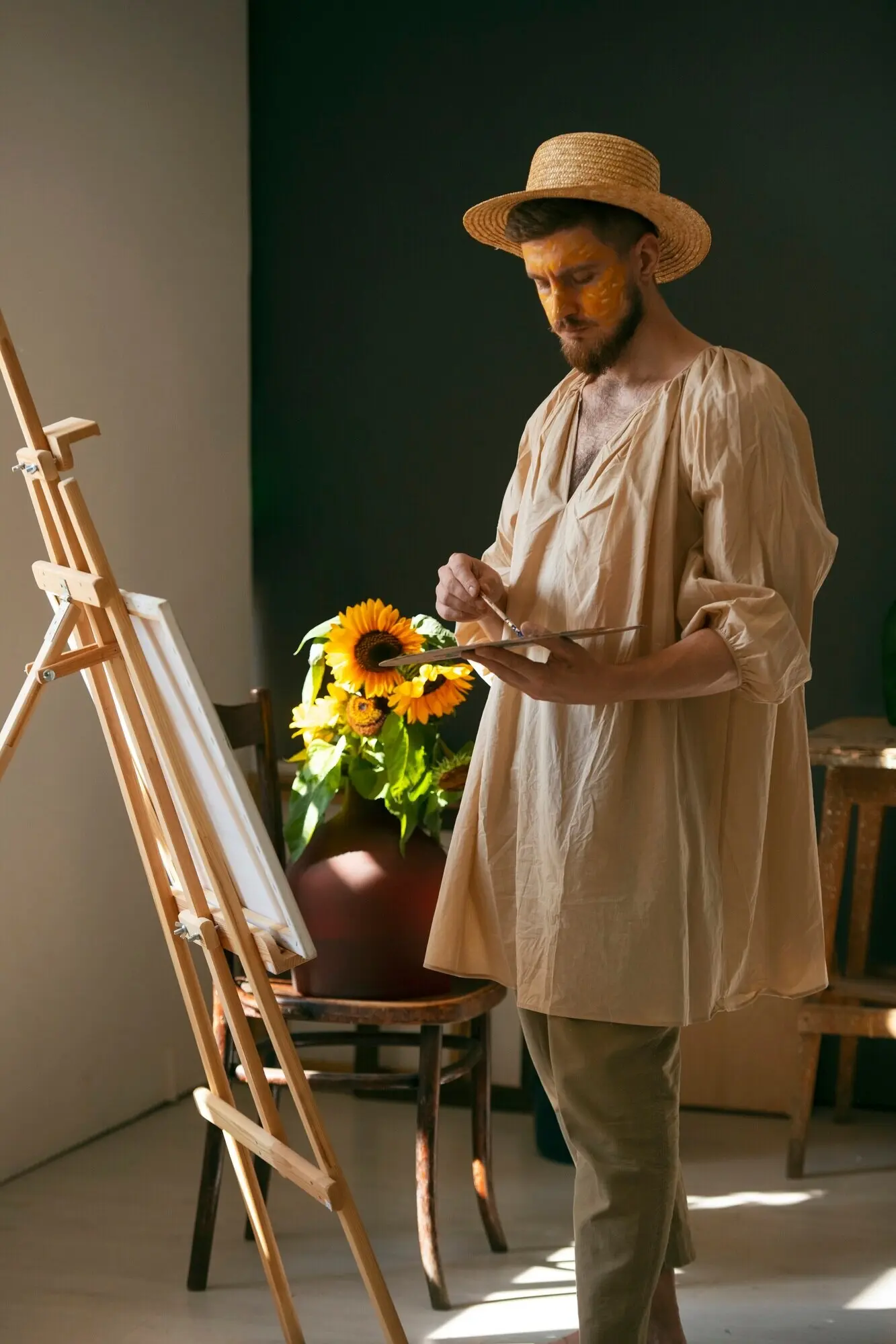 Ganzkörperaufnahme eines Mannes, der auf einer Leinwand malt.